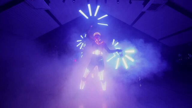 Laser led dance show. A group of dancers in glowing costumes dance. Laser show performance.