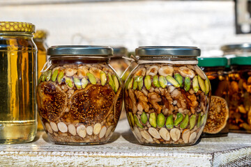 Honey in a glass jar with nuts and fruits for sell for tourist in Montenegro food market