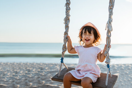 happy Little girl swinging at the beach