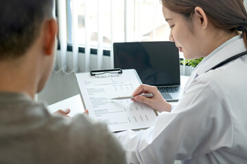 Fototapeta premium Doctor is pointing on document to explaining disease and symptoms for patient during to talking