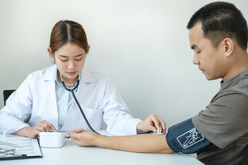 Doctor is checking blood pressure for the patient and using stethoscope to listening heartbeat