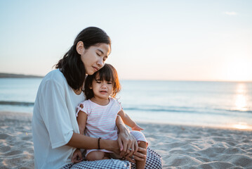 asian Mother is comforting her crying daughter