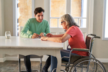 Elderly woman and son solve a brain teaser puzzle together