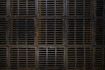 Old cast iron grating at the entrance to the subway. Drainage system. Natural geometric pattern. Urban reality. Metal underfoot. Album cover, website design and smm. Fear and sadness. 