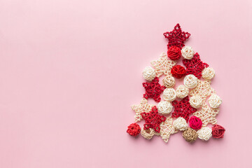 Obraz na płótnie Canvas Christmas tree made from colored handmade ball decoration on colored background, view from above. New Year minimal concept with copy space