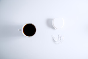 Flat lay top view of Isolated invisalign braces concept with cup of a coffee over white.
