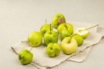 Trendy ugly organic apples on stone concrete background