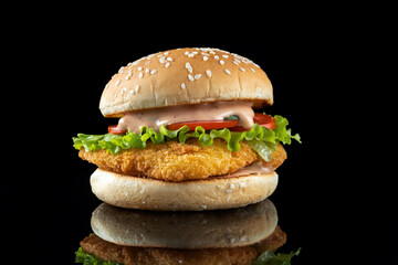 Burger with chicken cutlet, salad and mayonnaise. On a black mirrored background. Front view