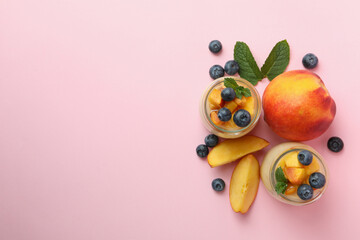 Concept of healthy food with peach yogurt on pink background