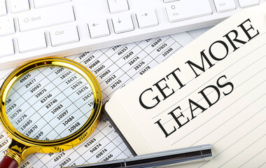 GET MORE LEADS text on notebook with chart, magnifier,keyboard and pen