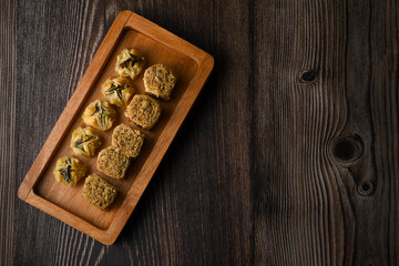 Turkish Baklava sweet pastry on wooden tray. Isolated wooden background