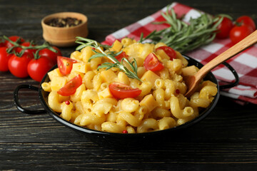 Concept of tasty eating with macaroni with cheese on wooden background