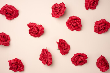red rose buds from textile on a beige background, top view