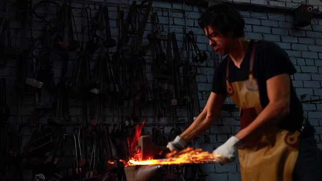 authentic italian brunette man blacksmith working in the workshop