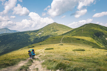 Fototapeta na wymiar mountain tourism concept. hiking in the mountains. two-wheelers with a backpack on their shoulders traveling the mountain slopes. summer vacation