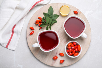 Fresh rose hip tea and berries on light table, flat lay