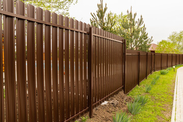 long brown fence. ventilated fencing for a farm or country house.