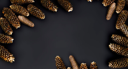 Autumn minimalist and simple composition in mat black and gold color. Winter decor, gold decorations on black background. Flat lay, top view with copy space. Autumn winter background.