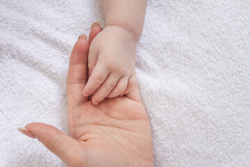 concept of motherhood. mother's hand holding the hand of a newborn baby. kids. parental care