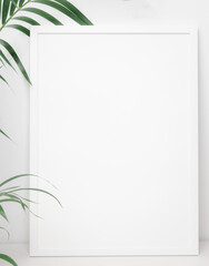 White poster frame decpration with green palm leaf over white wall background,copy space for your...