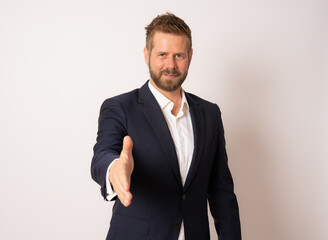 Happy smiling young business man giving hand for handshake, isolated over white background