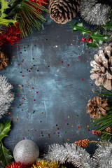 marco navideño con piñas de pino, acebo, espumillón, ramas de pino y bola decorativa, con...