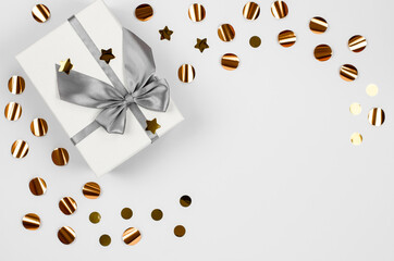 Festive greeting card. Christmas festive background with place for text. Large gift box and sequins on a white background. Festive concept.