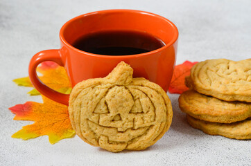 autumn halloween background fall leaves maple, sweet home made cookies shaped pumpkin,greeting card with copy space text,  thanksgiving day and festive baking item