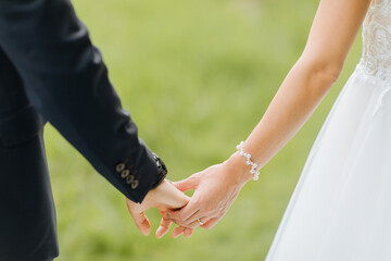 Bride and groom hold hands. Free wedding ceremony in summer. love 