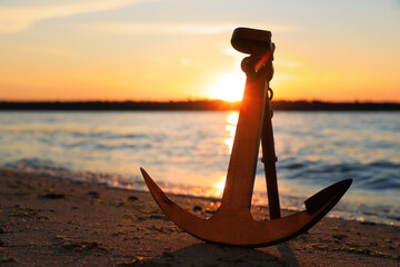 Wooden anchor on shore near river at sunset © New Africa