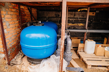 Hydraulic accumulator for water supply. metal tank with air chamber inside. the tank is connected...
