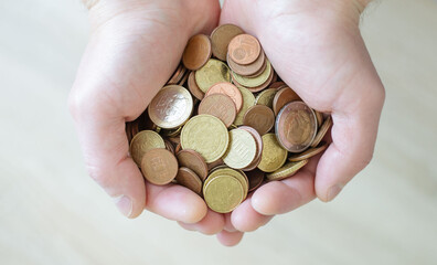 Closeup of male hand holding coins, saving concept