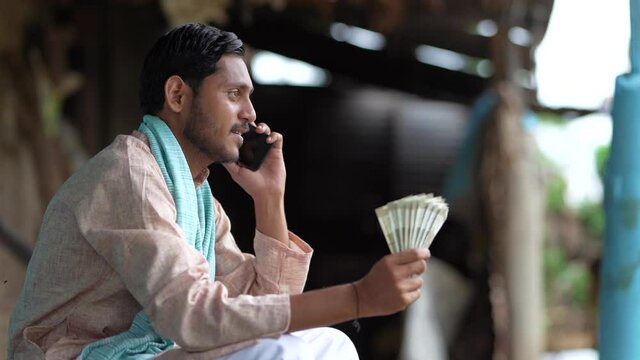 Happy Indian farmer counting money at home.