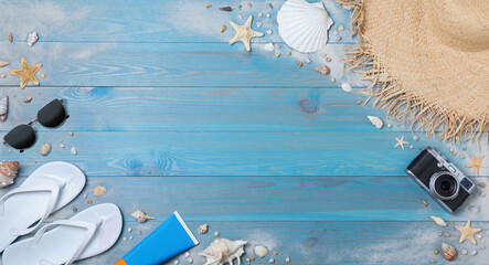Many different flip flops and beach objects on light blue wooden background, flat lay. Space for...
