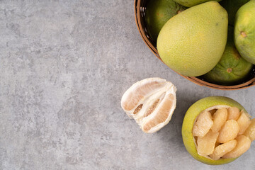 Fresh pomelo fruit on gray cement table background.