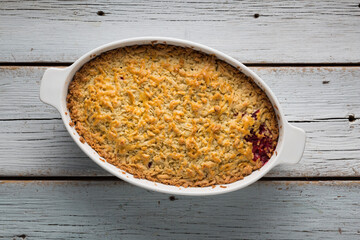 Grated pie with plums is prepared in the home kitchen, top view