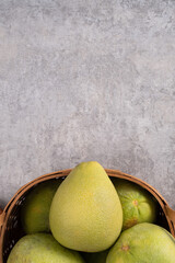 Fresh pomelo fruit on gray cement table background.