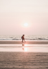 Couple walking along the ocean at sunset in Goa. Scenic view. High quality photo