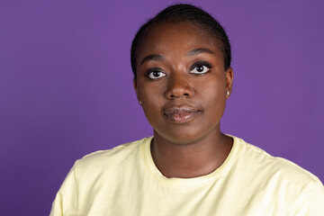 Half-length portrait of African charming woman isolated on purple, lilac color studio background. Concept of human emotions, facial expression, natural beauty, bodypositive