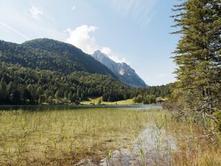 Fototapeta premium Von Mittenwald bis Lautersee. Seeufer Rundweg. Romantische Spaziergänge zwischen Wald und Moorwiesen am Fuße der Berge von Karwendel, Kranzberg und Wetterstein