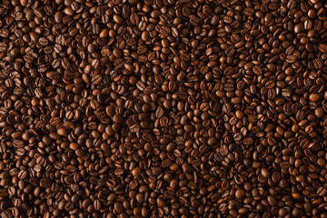 Background with heap of natural dry coffee beans close up