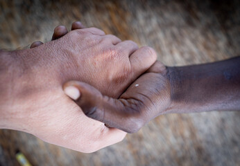 Fototapeta premium Two hands white and black making team together