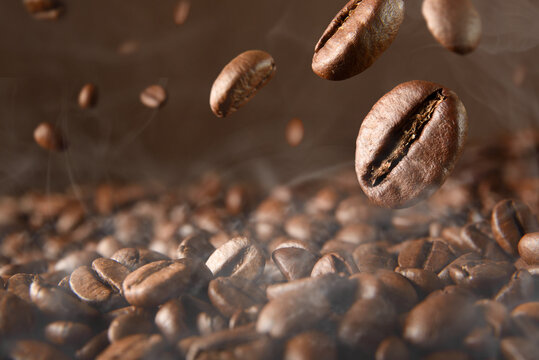 Roasted hot coffee beans falling on pile of coffee beans © Davizro Photography