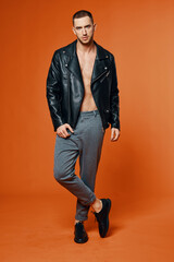 handsome man in leather jacket pumped up torso fashion studio isolated background