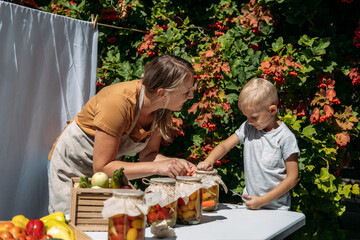 Canning Garden Vegetables, preservation of tomatoes, peppers, zucchini vegetables. Mom and son...