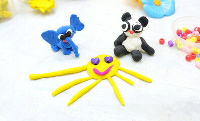 Child made  elephant, panda and sun from plasticine, colorful modeling clay and sculpting funny animals . Home Education game with clay. Early development .