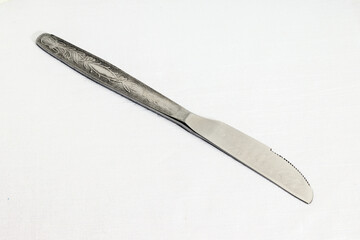 vintage table knife on white fabric background, close-up