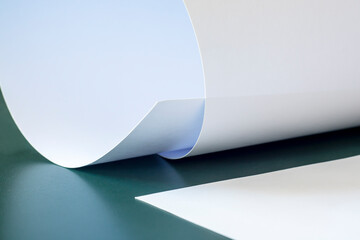 Sheets of white paper on a green table.