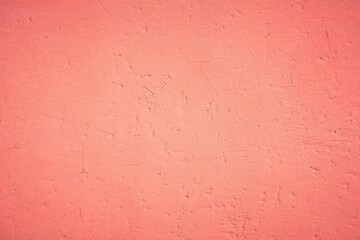 Old pink wall in spots, cracks, stains. Painted concrete wall in abstract grunge style loft. Vintage wall background texture for backgrounds, portraits, posters.