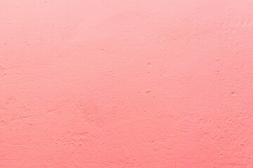 Old pink wall in spots, cracks, stains. Painted concrete wall in abstract grunge style loft. Vintage wall background texture for backgrounds, portraits, posters.